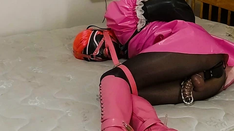 Chastised sissy maid in self-bondage with arm binder and dildo harness gag